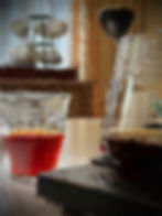Glass with red drink and another with a dark beverage