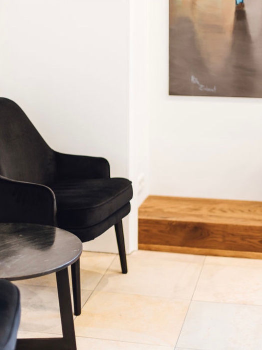 Wartebereich mit Sitzbank aus Holz und Kunst an der Wand, Praxisgestaltung von NIC interior.