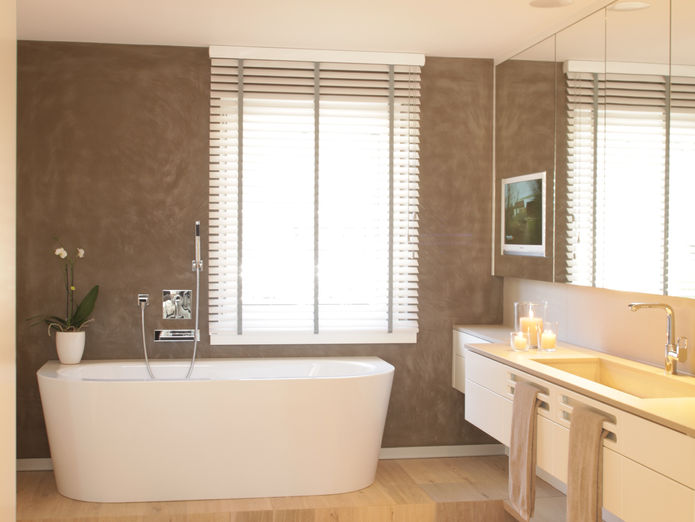 Freistehende Badewanne auf Podest, fugenlose Wände und Waschtisch aus Holz, gestaltet von NIC interior.