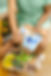 Two hands holding paint brushes and a palette of paintreaching for paints