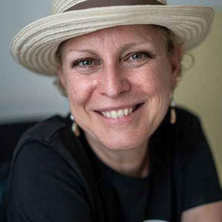 Portrait of Sara Turetta smiling while wearing a sun hat.