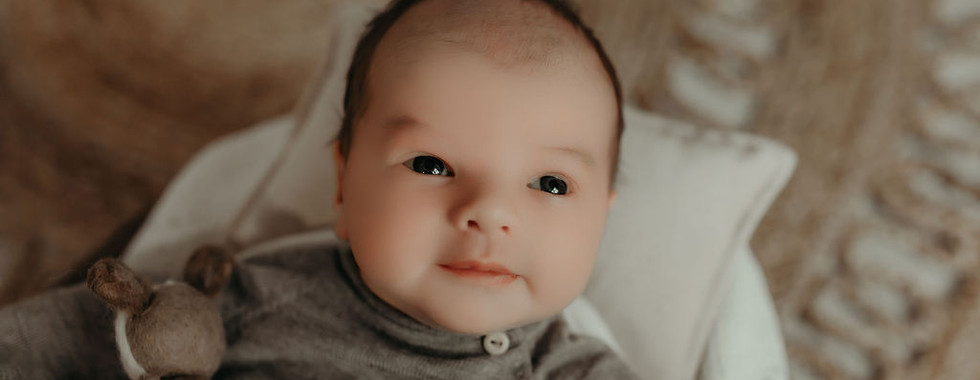 Awake newborn baby portrait in soft neutral tones, captured in a luxury Minneapolis newborn photography studio by Elsiebel Photography.
