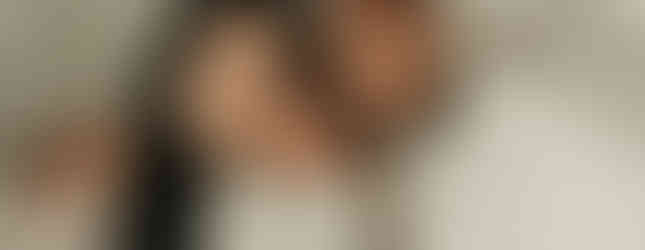 Parents holding newborn baby boy in a cozy neutral family portrait at Elsiebel Photography serving Maple Grove, Plymouth, and Minneapolis families