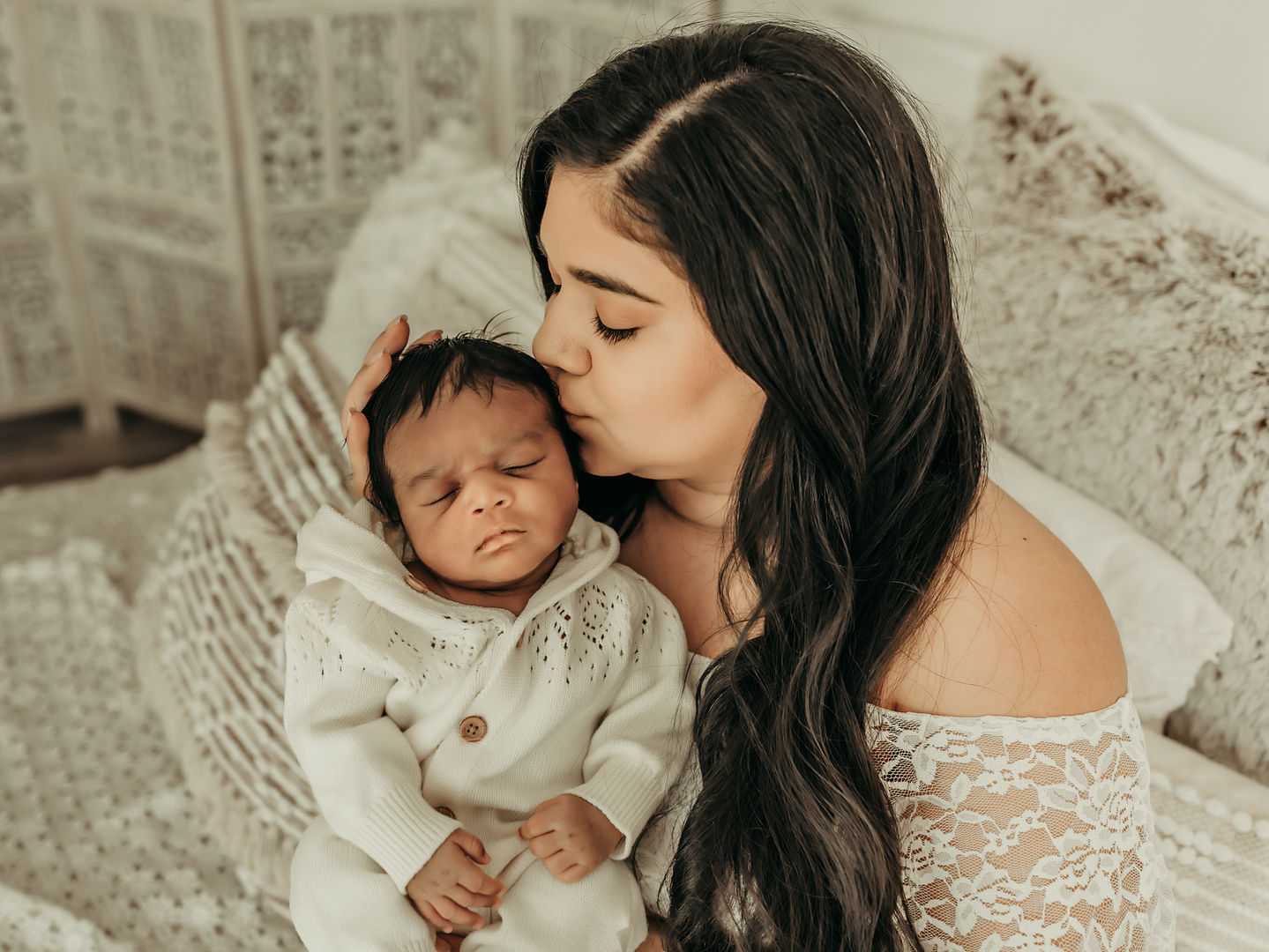 Mother kissing her newborn baby during a luxury newborn photography session at Elsiebel Photography serving Burnsville, Minneapolis, Edina, Eden Prairie, Maple Grove, and surrounding areas
