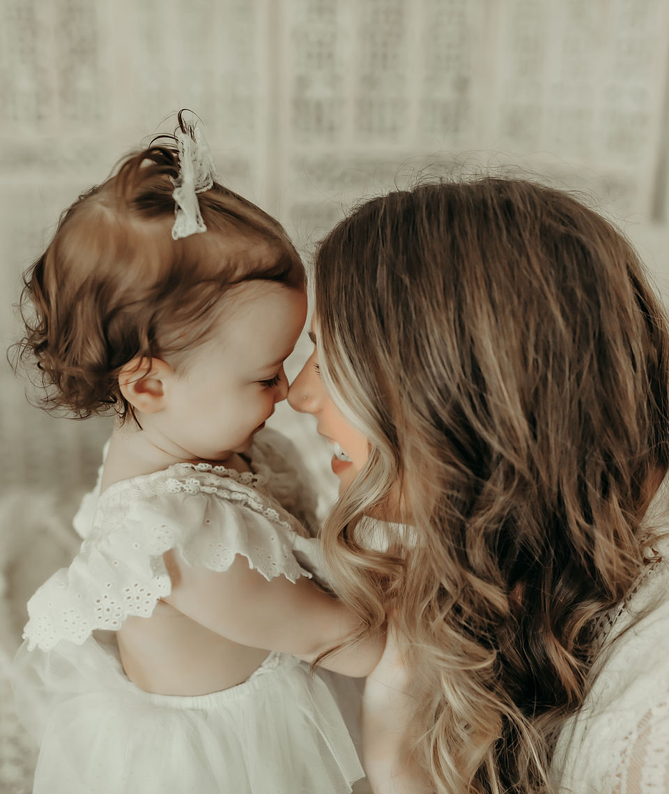 Mother kissing her baby girl during a luxury milestone photography session at Elsiebel Photography serving Burnsville, Minneapolis, Edina, Eden Prairie, Maple Grove, and surrounding areas