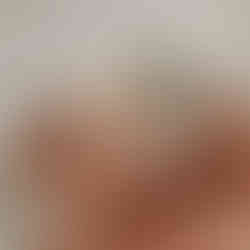 Sleeping newborn posed in a terracotta outfit with arms raised, photographed by Elsiebel Photography, a luxury newborn photographer in Minneapolis.