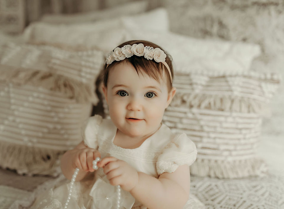 Baby girl celebrating her first birthday with cake smash photoshoot near Maple Grove Minnesota.