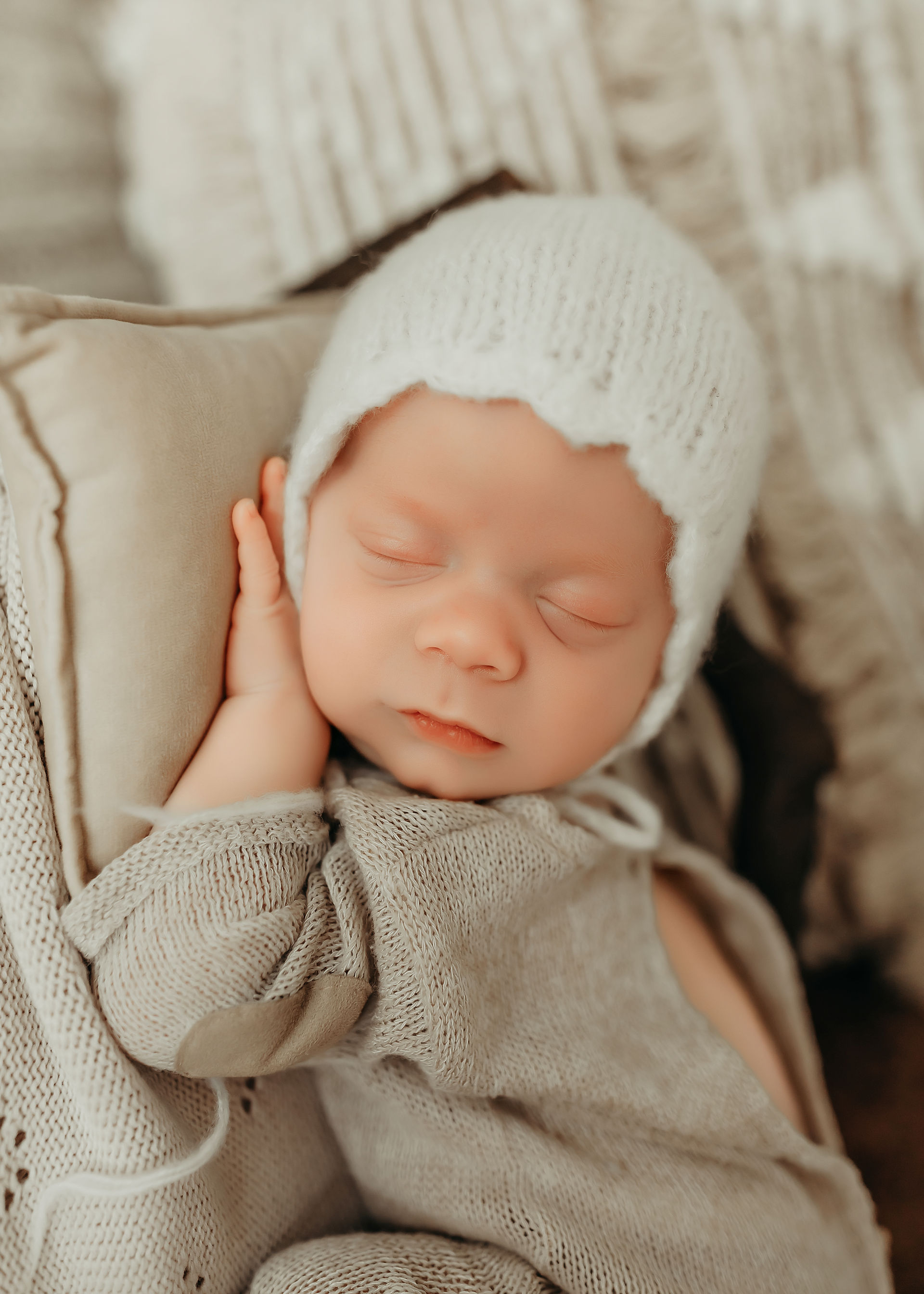Sleeping newborn baby wearing a white bonnet during a timeless newborn photography session in Minnesota.