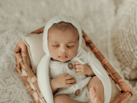 Sleeping newborn baby in a neutral knit outfit during a luxury newborn photography session at Elsiebel Photography serving Burnsville, Minneapolis, Edina, Eden Prairie, Maple Grove, and surrounding areas