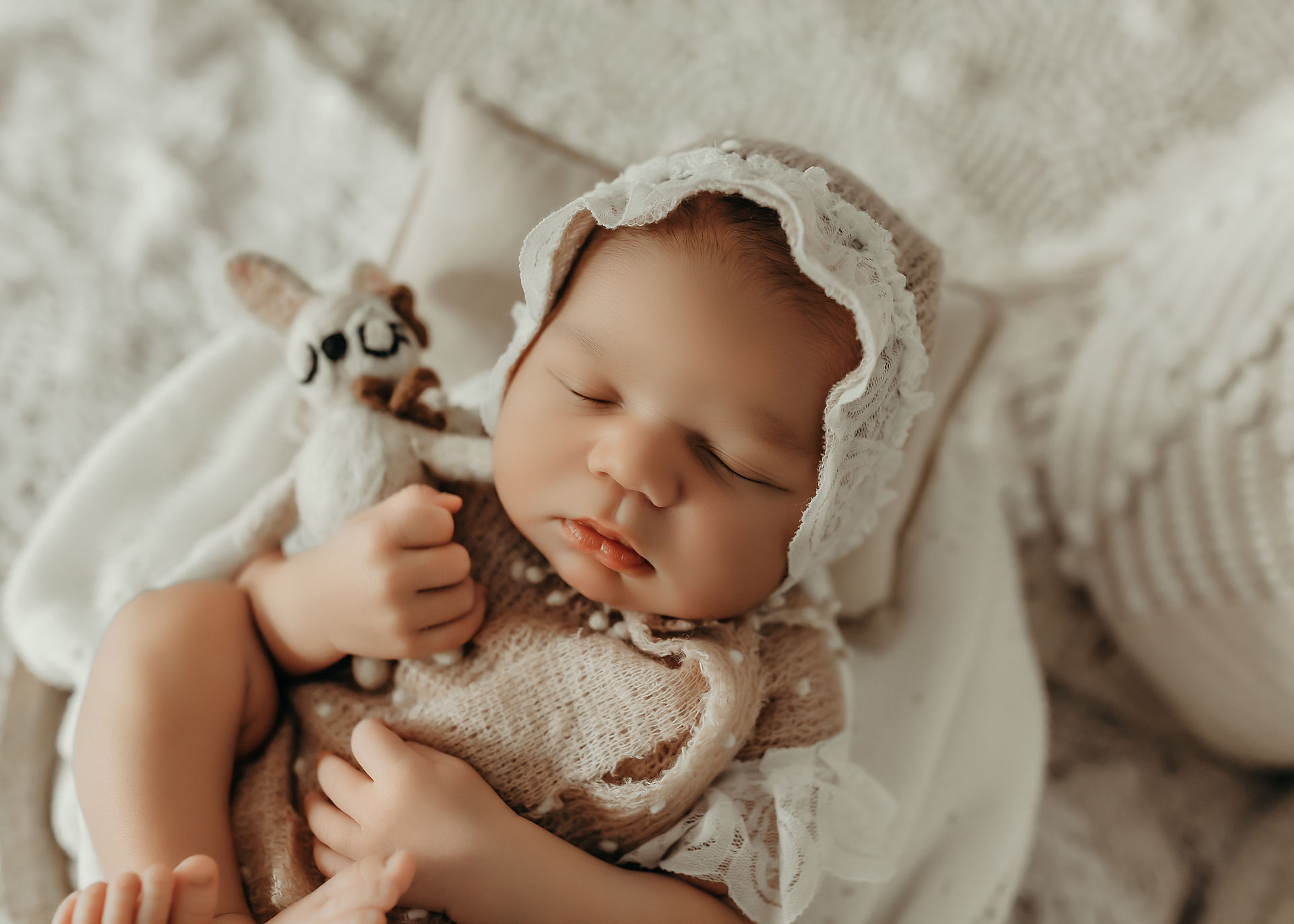 Peaceful newborn baby girl wrapped in soft neutral textures during a luxury Apple Valley newborn photography session.