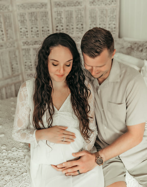 Expecting mom and dad holding her baby bump during a luxury maternity photography session