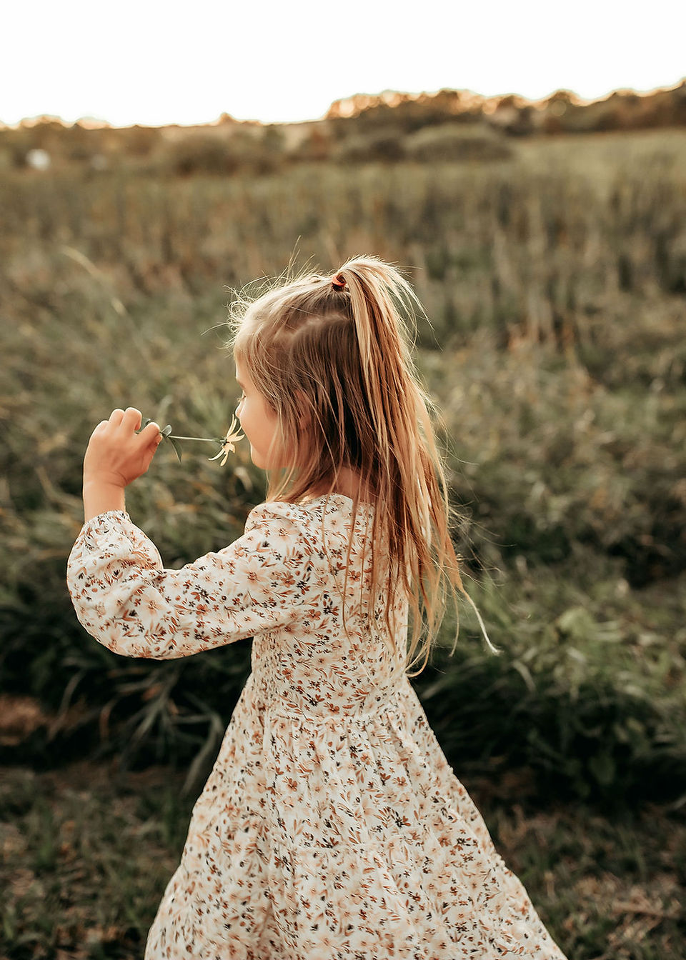 Mom holding her daughter during a warm outdoor family photography session