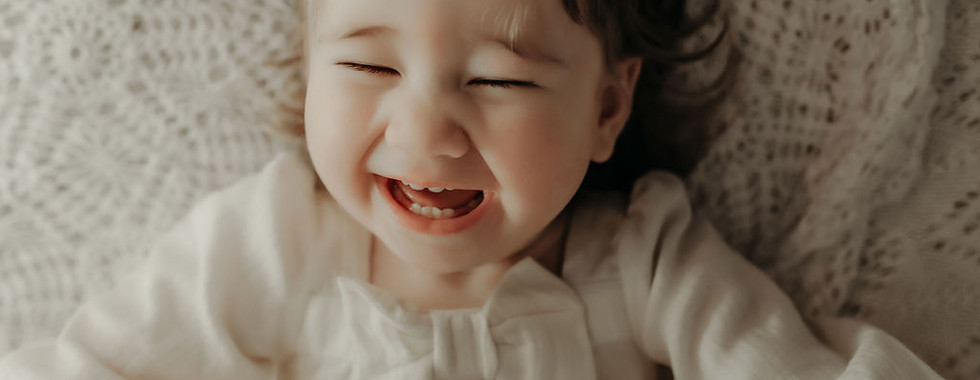 Smiling one-year-old girl in a neutral outfit during a luxury milestone session by Elsiebel Photography, Medina Minnesota baby photographer serving the West Metro.