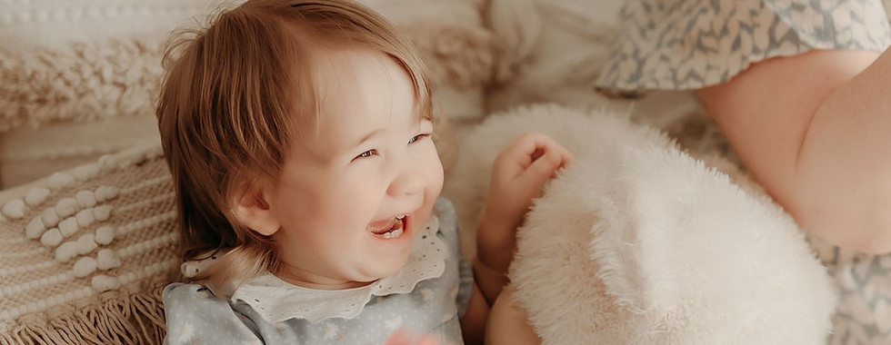 One-year-old resting comfortably in a soft, neutral studio setting captured by Elsiebel Photography in Medina, MN.