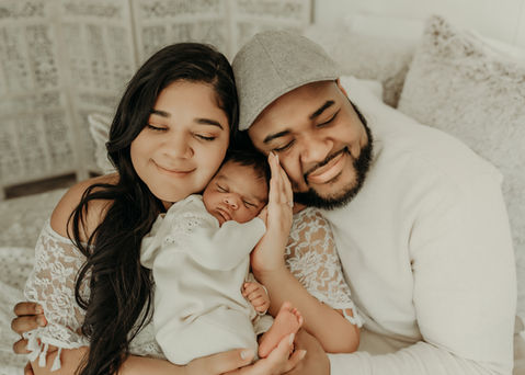 Parents cuddling their newborn baby during a luxury family newborn photography session at Elsiebel Photography serving Burnsville, Minneapolis, Edina, Eden Prairie, Maple Grove, and surrounding areas