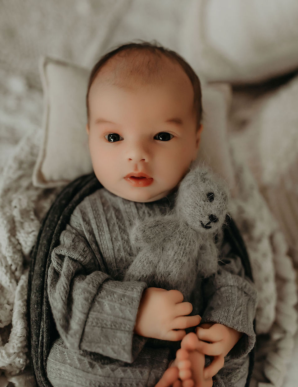Luxury newborn portrait of awake baby boy in neutral knit outfit, photographed in a soft timeless Minneapolis newborn photography studio by Elsiebel Photography.