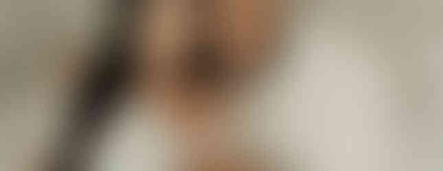 Family portrait with mom, dad, and newborn baby boy in soft neutral tones during a luxury Maple Grove newborn photography session