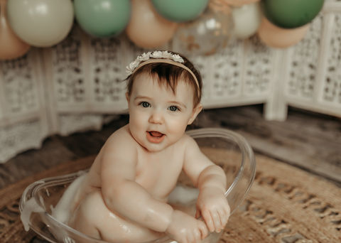 Smiling baby girl during a luxury first birthday cake smash session at Elsiebel Photography serving Burnsville, Minneapolis, Edina, Eden Prairie, Maple Grove, and surrounding areas