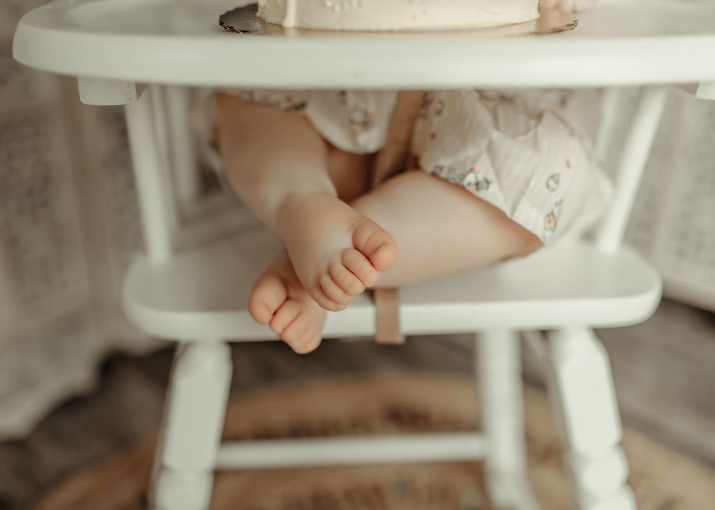 Close-up of baby feet on a chair during a luxury cake smash photography session at Elsiebel Photography serving Burnsville, Minneapolis, Edina, Eden Prairie, Maple Grove, and surrounding areas