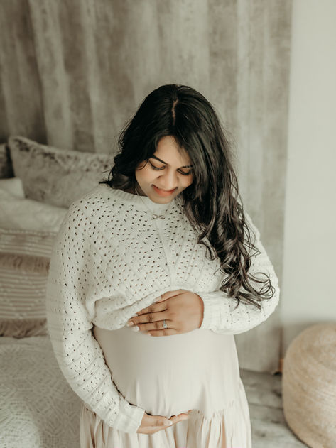 Expectant mother looking down at her baby bump during a luxury maternity photography session at Elsiebel Photography serving Burnsville, Minneapolis, Edina, Eden Prairie, Maple Grove, and surrounding areas
