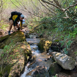 Scrambling over boulders along a mountain stream on the way down from Mt. Myoko