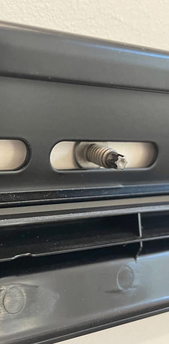 Close-up of a bolt secured through a black metal bracket using The UUScrew®