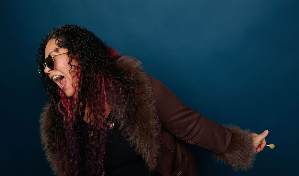 VO Artist, Vox Goddess, and Coach Cia Court  sunglasses, fur coat, singing with a lollipop