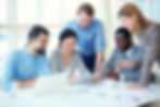 Five diverse business people collaborating around a table