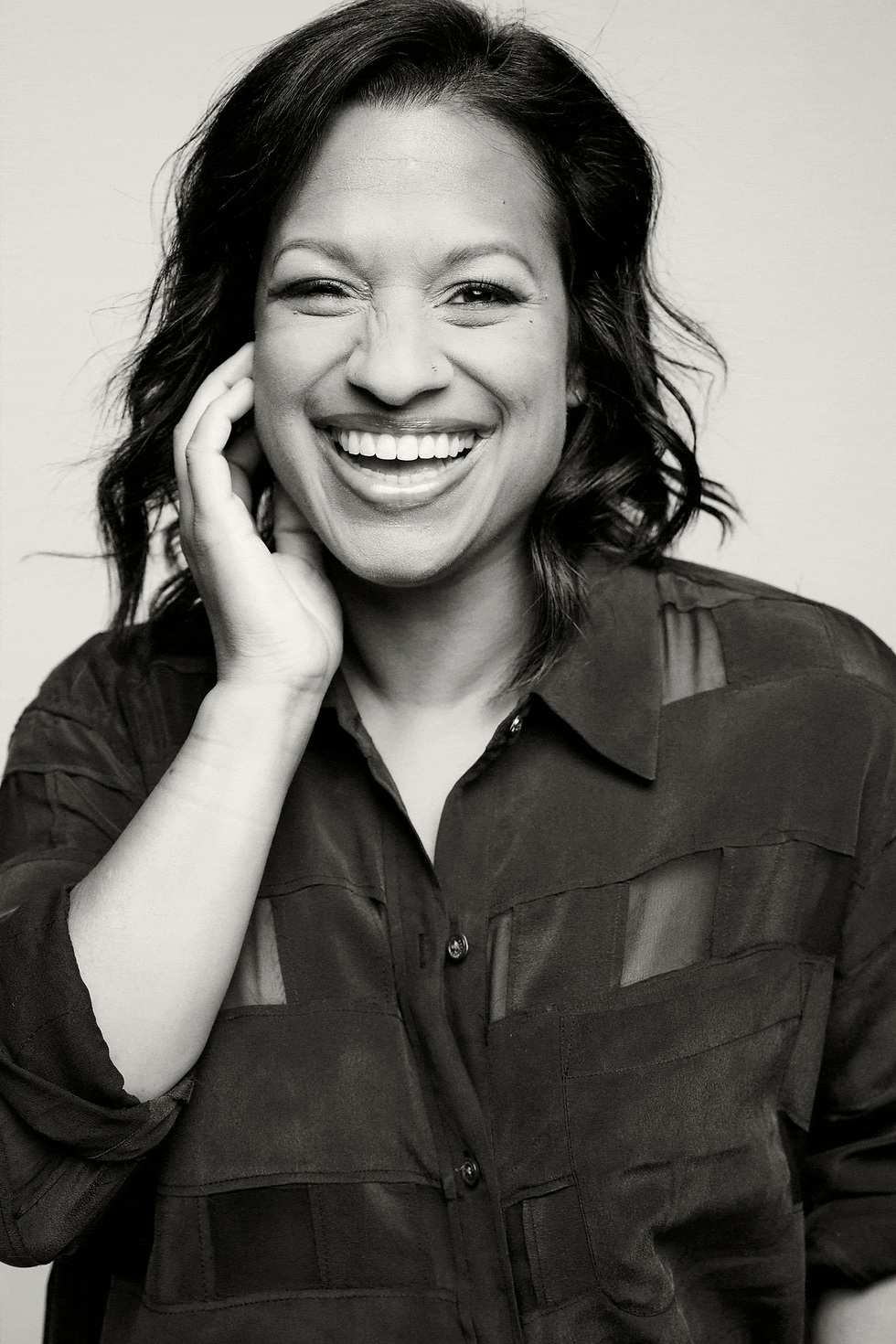 Writer and Performer Rati Gupta iin a black button down laughing in sequence GIF