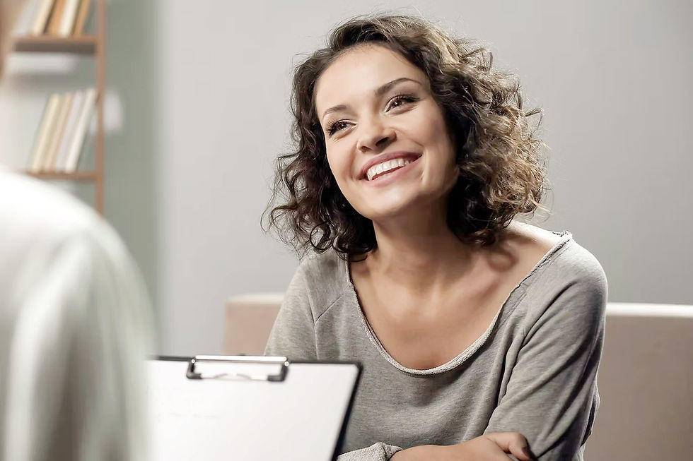 Smiling female patient sitting at in-person consultation at Demeter's Garden medical spa in Asheville, NC.