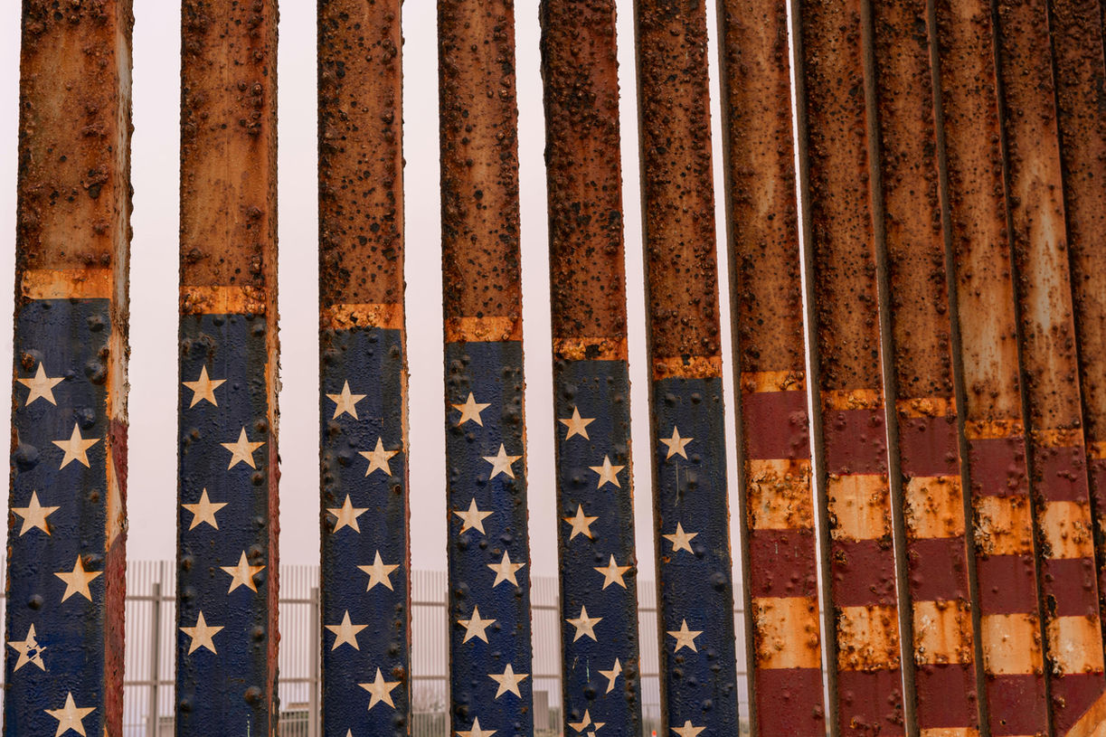 An American flag painted and rusted over on the U.S.-Mexico border wall.