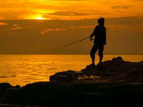 man fishing at sunset