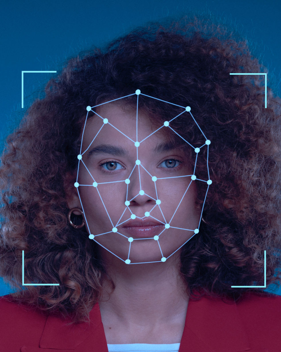 Woman's face with facial recognition grid on a phone screen