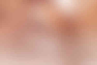 bride and groom holding hands in front of double arches