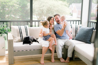 Family of four and a pug on their porch