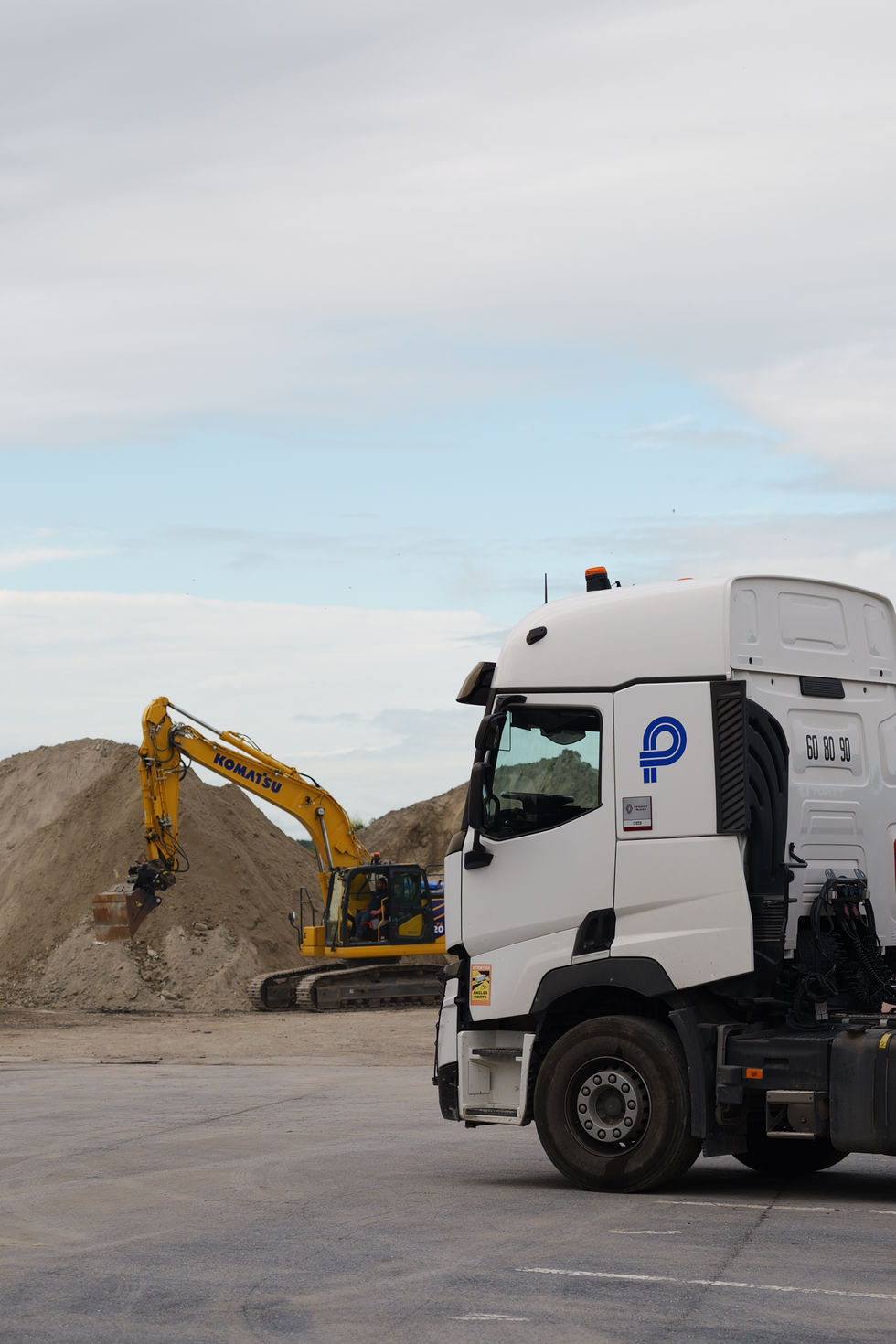 Camion et pelle mécanique SATN sur un chantier de travaux publics.