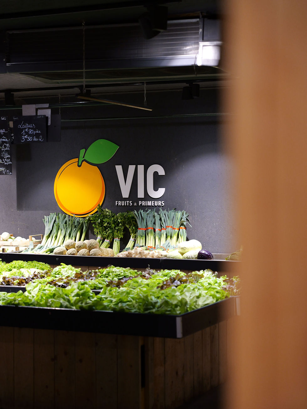 Légumes frais en rayon sous l'enseigne VIC avec le logo orange.