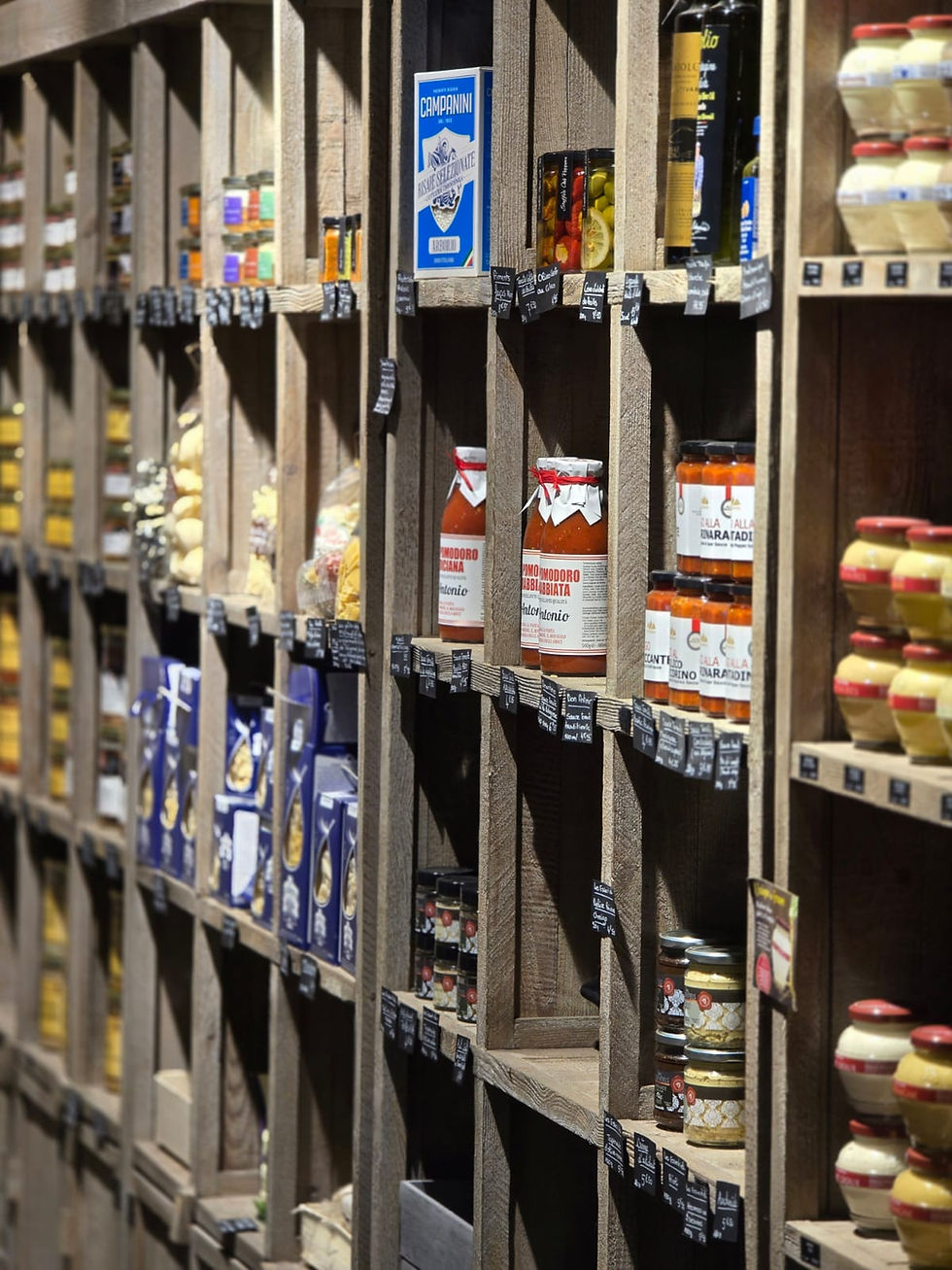 Étagères en bois remplies de divers produits alimentaires dans une épicerie.