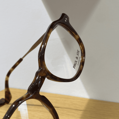 Lunettes de vue PAUL & JOE, monture écaille sur étagère lumineuse.