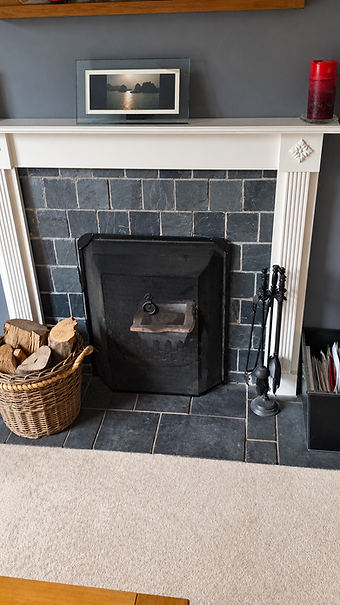 Traditional cast iron fireplace with slate hearth and log basket