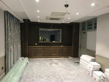 Commercial interior with dark timber partition wall ambient ceiling lights and plush sofa