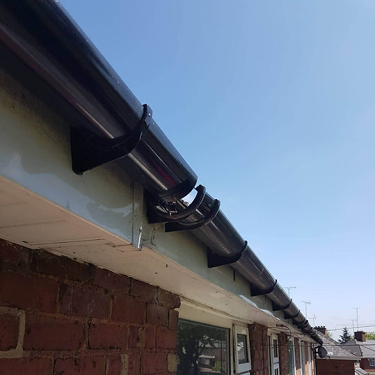New black guttering installed beneath roof tiles