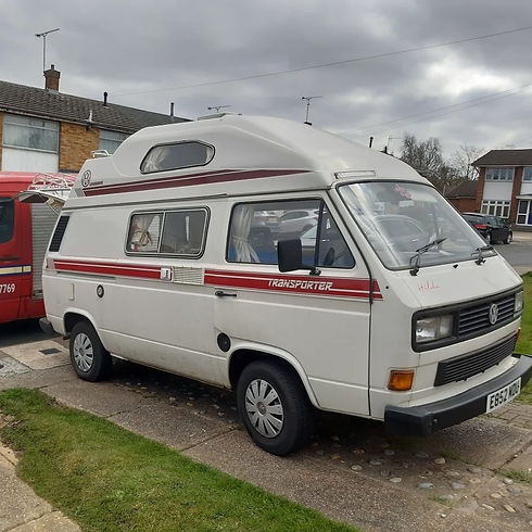 White vintage VW Transporter campervan with a high-top roof