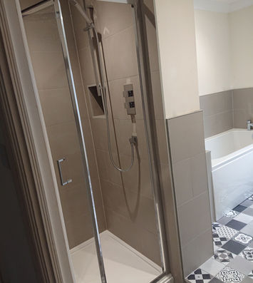Sliding glass shower enclosure with chrome fittings