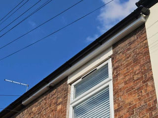 Red brick house facade with white window on a clear day