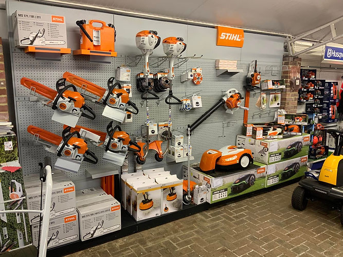 Garden machinery showroom displaying robotic mowers, chainsaws, leaf blowers, trimmers, and other garden equipment