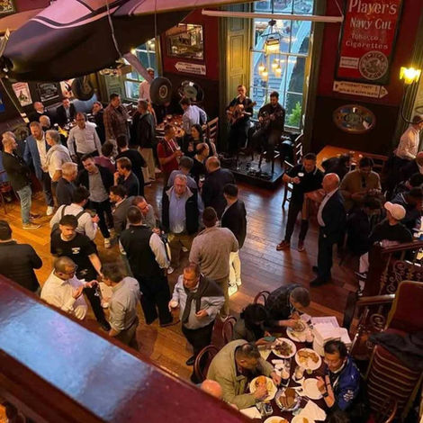 Guests mingling in the event venue room at The Merchant's Arch during a lively evening.
