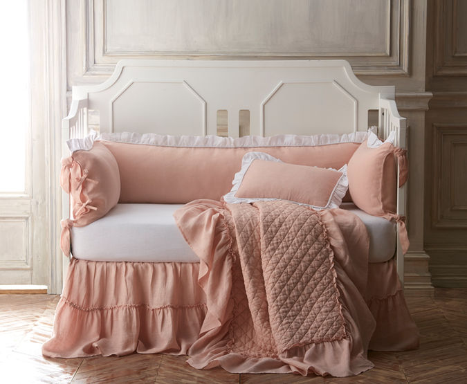 Pink baby bedding on a crib in a traditional room