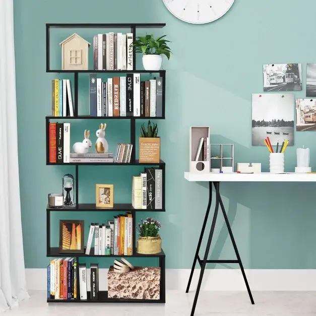 Black S-shaped bookshelf filled with books and decor