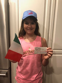 A young girl holding an Italian flag and wearing a Chi-Chi's hat
